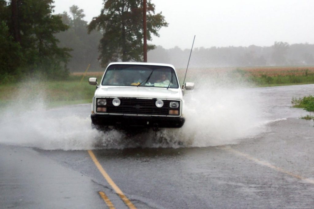 The truck drives through a flooded road