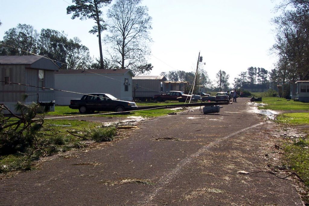 A downed utility pole and debris on a residential road