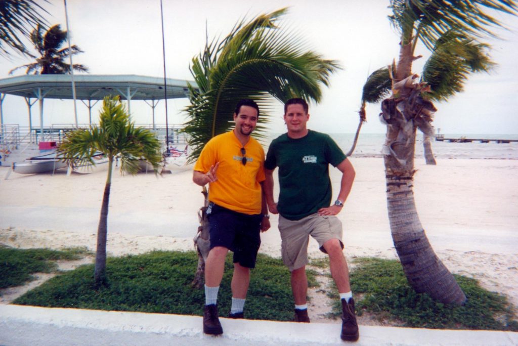 Luis Aponte and Forrest Masters stand next to a Key West palm tree