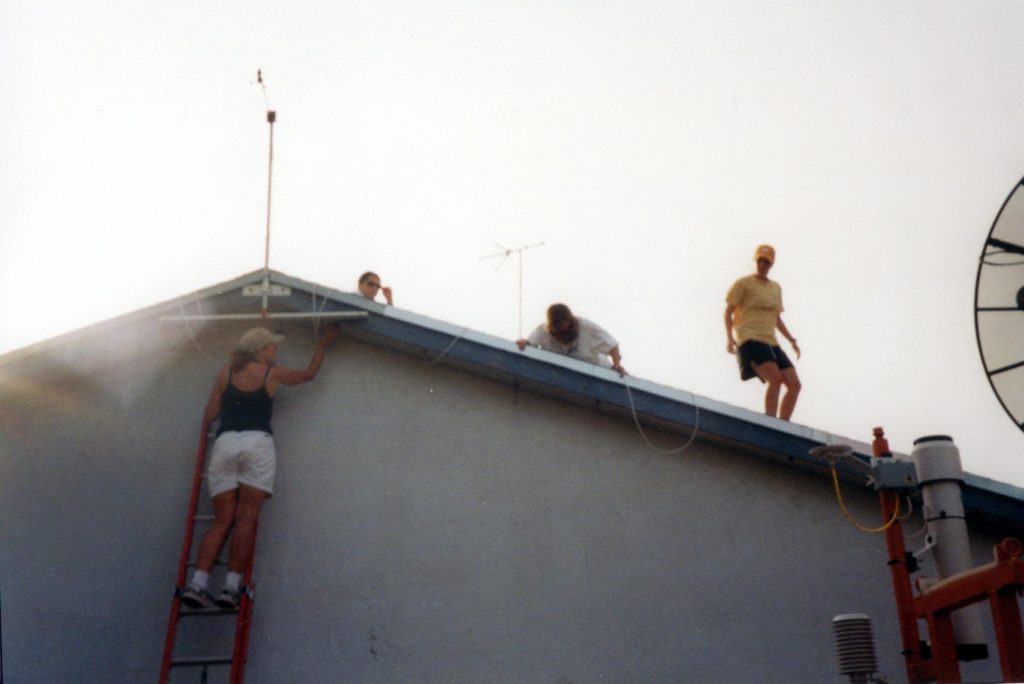 The team attaches sensor cables to the roof of a house