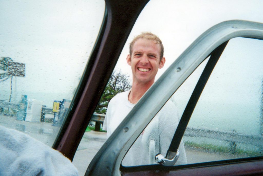 Scott Robinette smiling through the gap in the open van door
